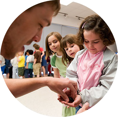 an entomology student shows some kids a cockroach